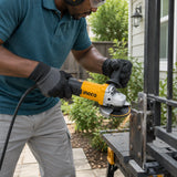 African American homeowner using an Ingco AG90028 angle grinder to smooth a secured steel garden-gate latch plate.