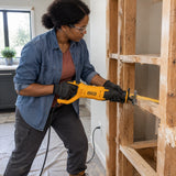 African American home renovator using the corded Ingco RS12001 reciprocating saw to cut a timber storage frame.