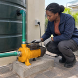 African American homeowner checking an Ingco CPM37068 centrifugal pump transferring water through connected residential service lines.