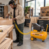 African American workshop operator using a pneumatic air tool connected to an Ingco 24L compressor to clear sawdust from a drawer component.