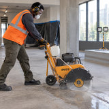 African American concrete-cutting operator guides a compatible Ingco floor saw fitted with the 405mm DMD044053 diamond disc through a marked slab