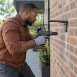 African American masonry installer drilling a controlled fixing hole in a brick wall with an Ingco hex-shank masonry bit