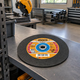 Ingco 355mm abrasive cutting disc stored flat on a clean shelf in a professional metal fabrication workshop