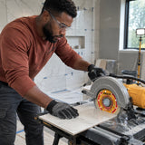 African American tile installer using an Ingco flanged diamond disc to wet-cut ceramic tile during a bathroom renovation