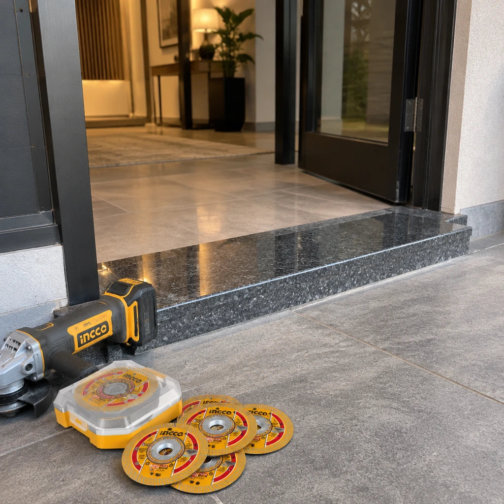 Completed granite entrance threshold with an inactive cordless grinder and Ingco diamond disc set nearby