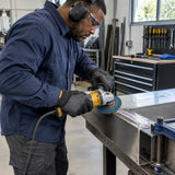 African American metal technician using an Ingco FDZ1151 P40 flap disc on a stainless-steel weld in a fabrication workshop