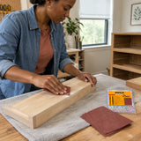 African American adult hand-sanding a wooden drawer front with an Ingco abrasive sanding sheet in a home workshop