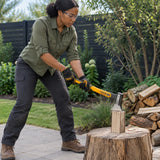 African American adult using an Ingco HAX081600 600g axe to chop a small piece of firewood on a backyard block