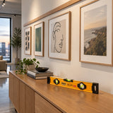 Finished gallery picture rail with aligned framed prints and Ingco spirit level resting on a console