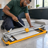 Tile installer scoring a ceramic floor tile with an Ingco 600mm manual cutter in a kitchen renovation workspace