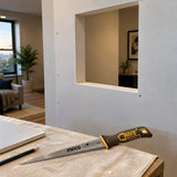 Completed wall-board section fitted around an opening with the inactive Ingco HWBSW1506 saw resting nearby.