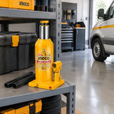 Ingco HBJ1002 hydraulic bottle jack stored upright in an organised professional vehicle maintenance bay.