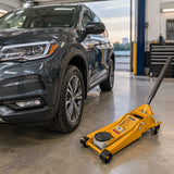 Serviced car ready in a professional garage with the inactive Ingco HFJ402 floor jack parked beside it.