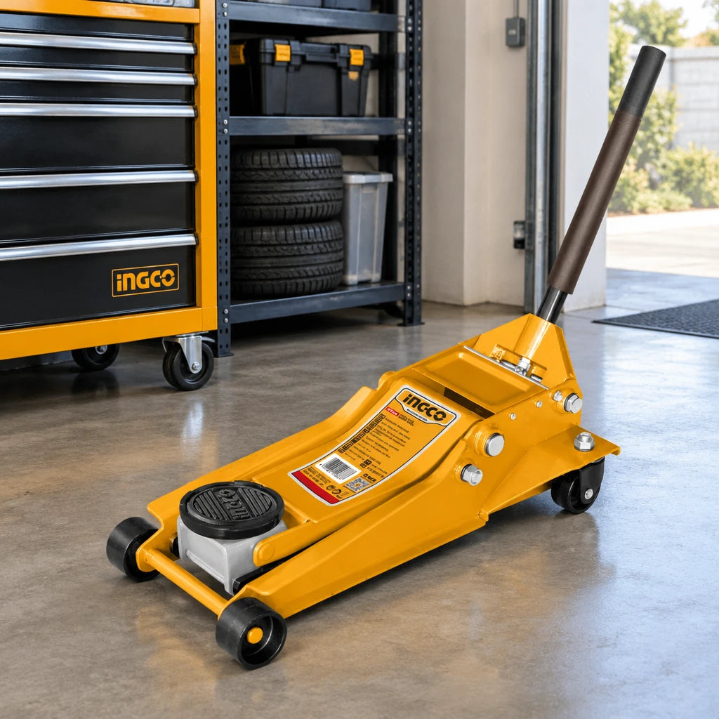 Ingco HFJ402 hydraulic floor jack parked on the floor in an organised automotive workshop.
