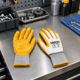 Ingco HGNG64 nitrile work gloves resting at an organised oil-assembly workstation.