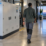 Technician wearing Ingco WUCT8022.L reinforced work trousers walks past a completed commercial service cabinet