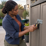 Homeowner uses a key to secure an Ingco DIPL0401 padlock on an outdoor garden storage cabinet