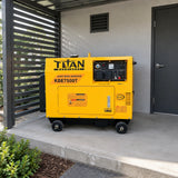 Titan yellow silent diesel generator parked on wheels in a covered commercial service alcove beside a contemporary design studio.