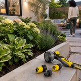 Refreshed courtyard garden after watering with the Kärcher spray gun resting beside the planting bed