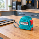 Total turquoise and red metric tape measure resting on an organised home workshop workbench before a project.