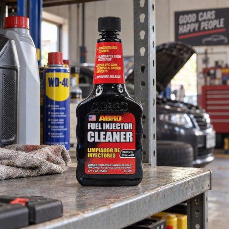 Closed Abro IC-509 fuel injector cleaner bottle resting on an organized automotive garage shelf