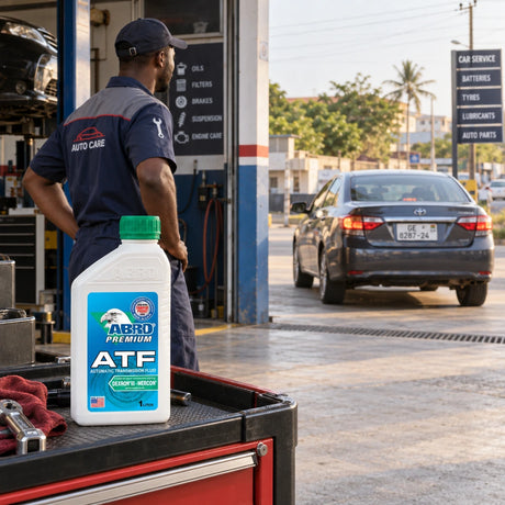 Serviced car leaves a Ghanaian workshop with an Abro Premium ATF bottle visible on the service cart