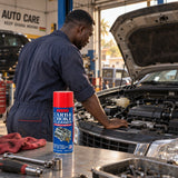 Mechanic listening to a smoothly running vehicle after using Abro Carb and Choke Cleaner, with the can on the workbench