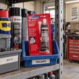 Unopened Abro Black RTV Silicone Gasket Maker stored in a parts bin on an automotive workshop shelf.