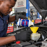 Technician carefully pouring Abro 99 DOT 3 brake fluid into a vehicle brake-fluid reservoir