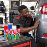 Refinished vehicle trim inspected beside Abro spray paint cans in a Ghanaian auto detailing bay