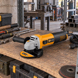 Coofix electric angle grinder resting on a wooden tool shelf in a Ghanaian metal workshop