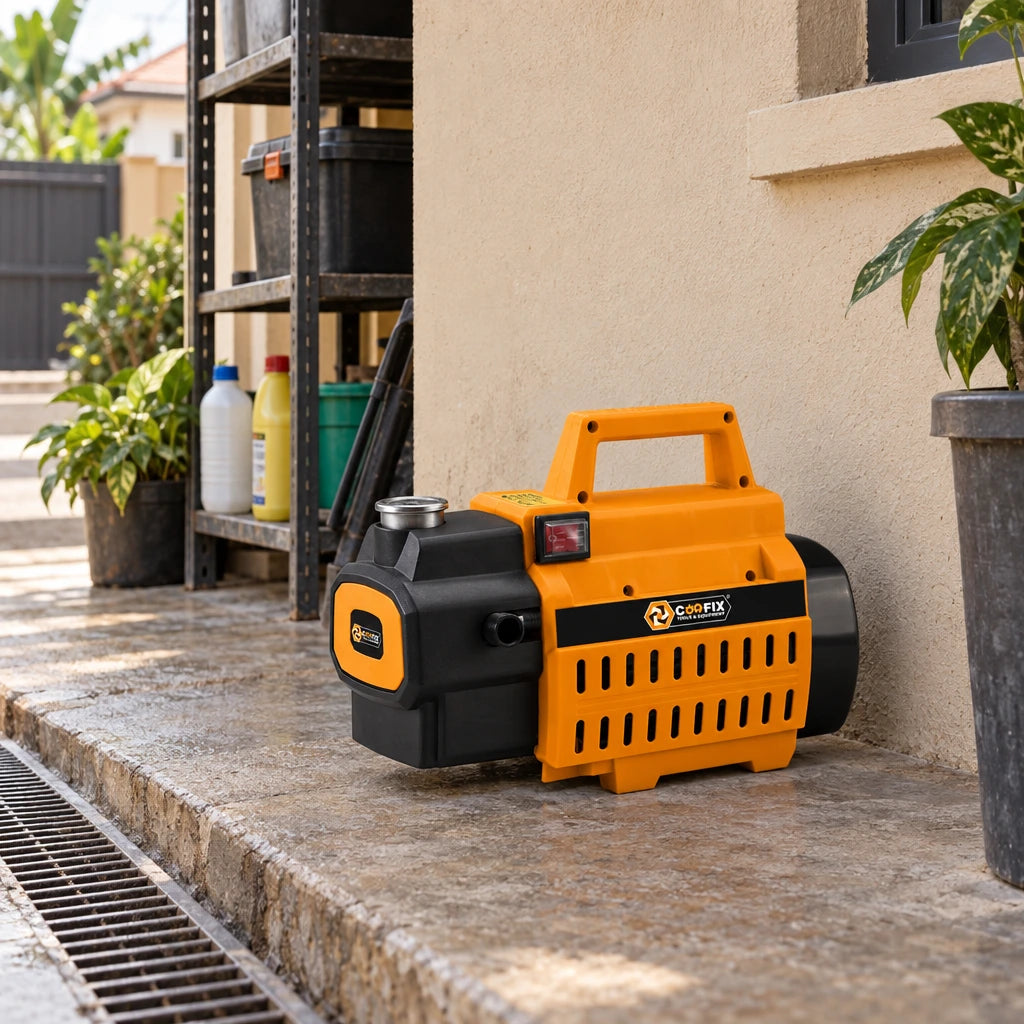 Coofix orange pressure washer parked on a concrete utility area beside a Ghanaian home