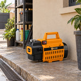 Coofix orange pressure washer parked on a concrete utility area beside a Ghanaian home