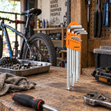 Coofix orange nine-piece hex key set resting on a bicycle repair workshop bench