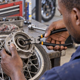 Ghanaian motorcycle technician using Coofix bent-head circlip pliers to remove a recessed retaining circlip