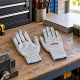 Coofix XL cut-resistant work gloves resting on a workshop bench beside prepared sheet materials
