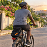 Ghanaian cyclist riding a bicycle after using a Coofix compact hand inflator stored on the bike