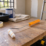 Coofix 4-inch paint roller resting on a workbench in a home painting preparation area