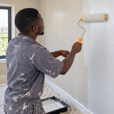 Ghanaian painter using a Coofix 9-inch roller frame with a compatible cover on an interior wall