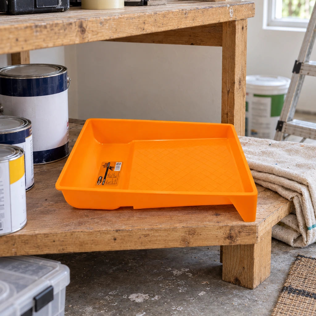 Coofix orange paint tray resting on a lower shelf of a home decorating workbench before painting