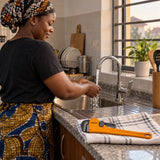 Ghanaian homeowner testing a leak-free tap after a Coofix pipe wrench repair