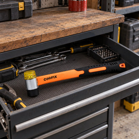 Coofix dual-face rubber and plastic hammer resting in an open workshop tool drawer