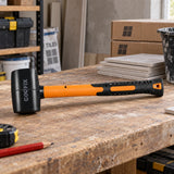 Coofix black rubber mallet resting on a workshop bench beside tile materials