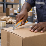 Ghanaian warehouse worker using a Coofix snap-off blade knife to cut open a cardboard carton
