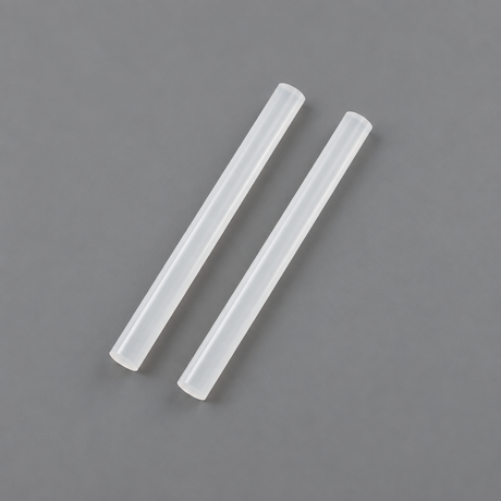 Two Coofix glue sticks on grey