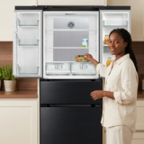 Woman placing groceries into the open Kaiser French door refrigerator, based on your open-fridge reference