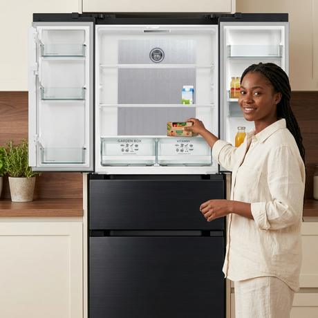 Woman placing groceries into the open Kaiser French door refrigerator, based on your open-fridge reference